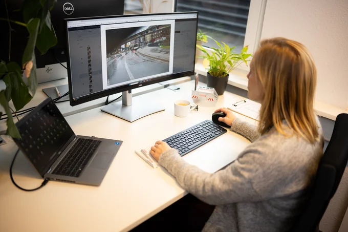 Frau sitzt bearbeitet Foto einer Straßenansicht am Computer