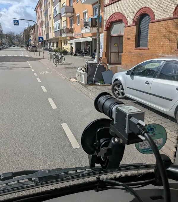 Blickdurch Windschutzscheibe auf Straße mit illegaler Müllablagerung
