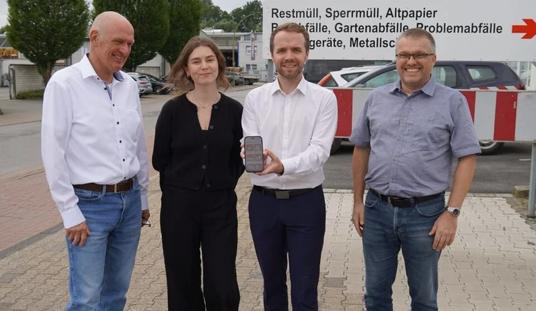 Vier Menschen vor einem Wertstoffhof