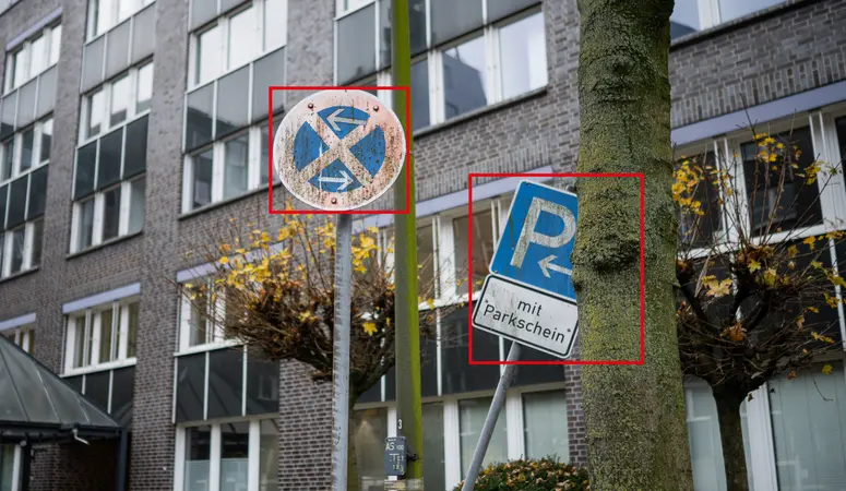 zwei verschmutzte Verkehrsschilder vor Bürogebäude
