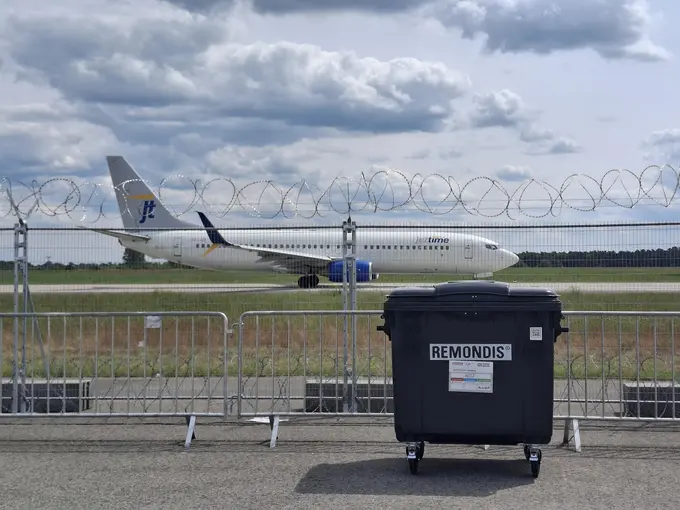 REMONDIS Abfallcontainer vor Flugzeug auf dem Rollfeld